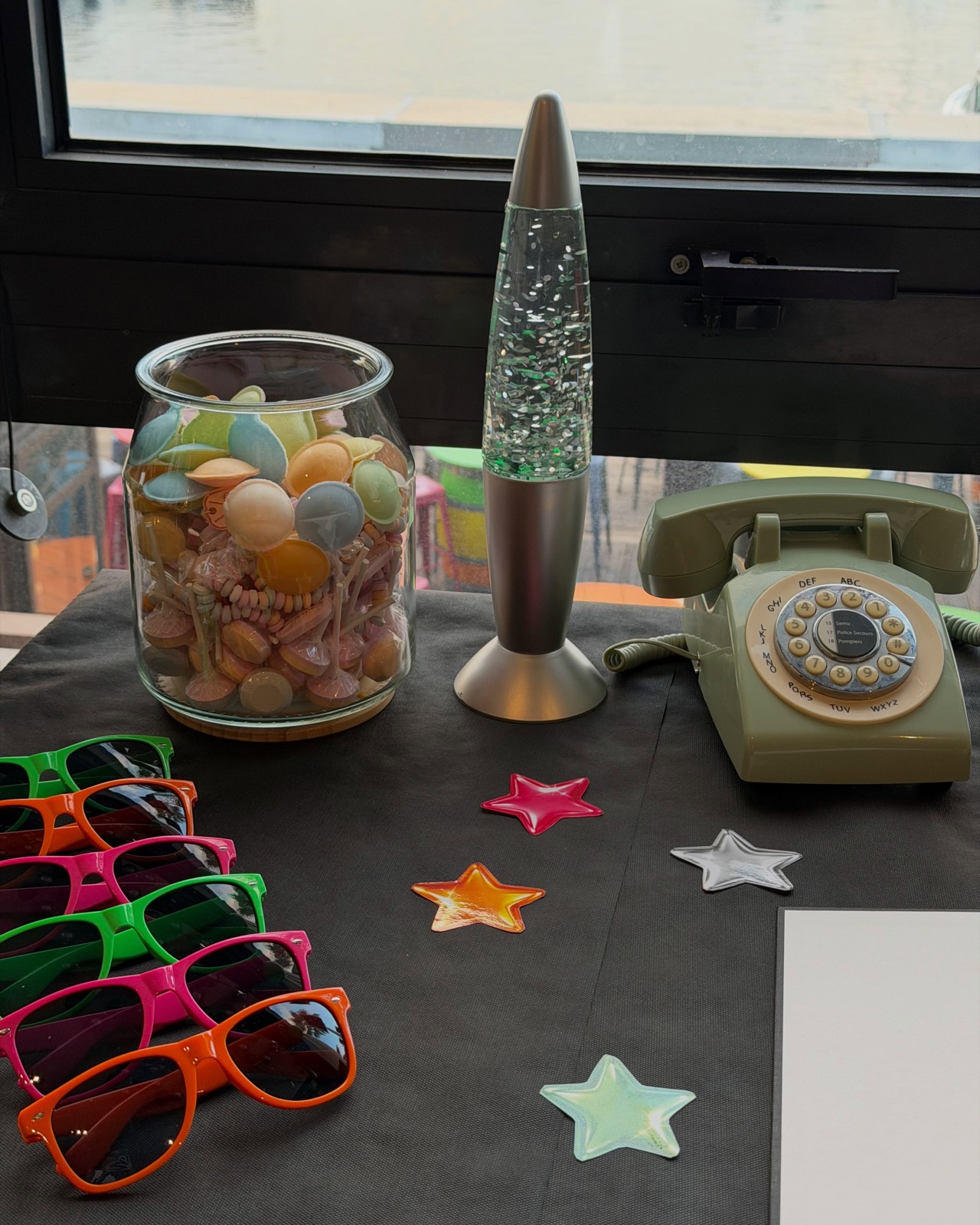 Lunettes colorées, lampe à lave et téléphone vintage pour un décor années 80