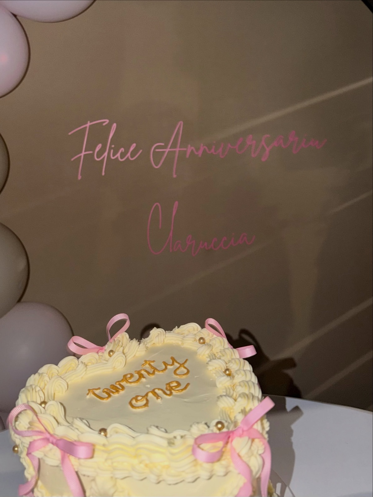 Gâteau crème « twenty one » orné de nœuds roses devant l’arche