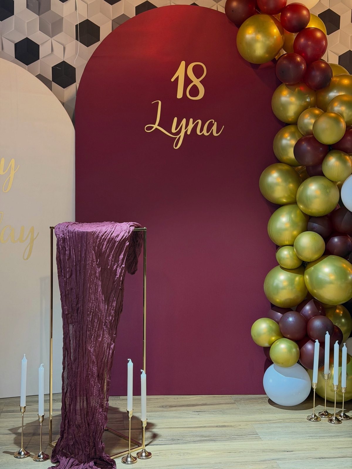 Arche bordeaux personnalisée « 18 Lyna » entourée de ballons or et bordeaux